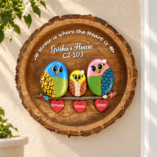 Lively Family Pebble Art: three colourful birds on a round wooden plaque with heart-shaped name tags, in a home setting