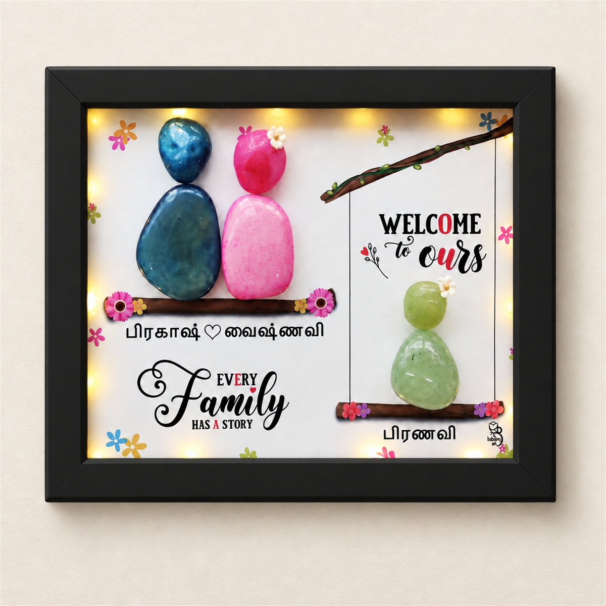 Love Nest Trio Pebble Art Gift: three colourful pebble figures on two branches with a family message, black frame, on a beige background