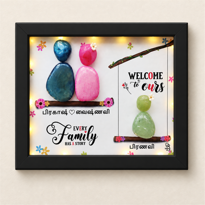 Love Nest Trio Pebble Art Gift: three colourful pebble figures on two branches with a family message, black frame, on a beige background