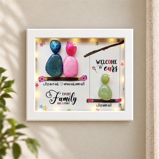 Love Nest Trio Pebble Art Gift: three colourful pebble figures on two branches with a family message, white frame, in a home setting