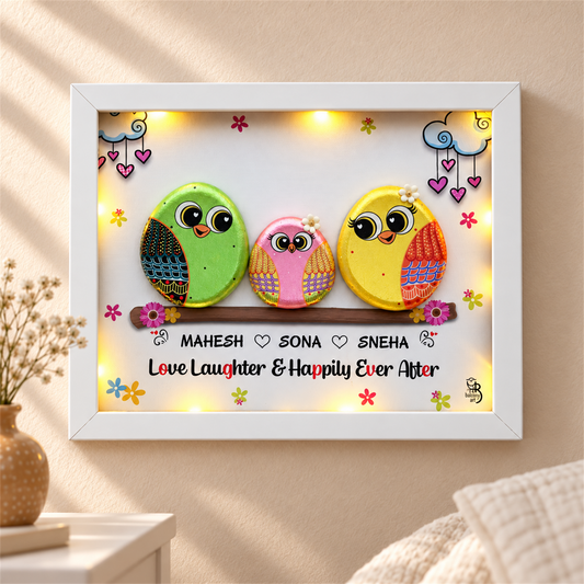 Spark of Grace Trio: green, pink and yellow little birds on a flower-trimmed branch, white frame, in a home setting